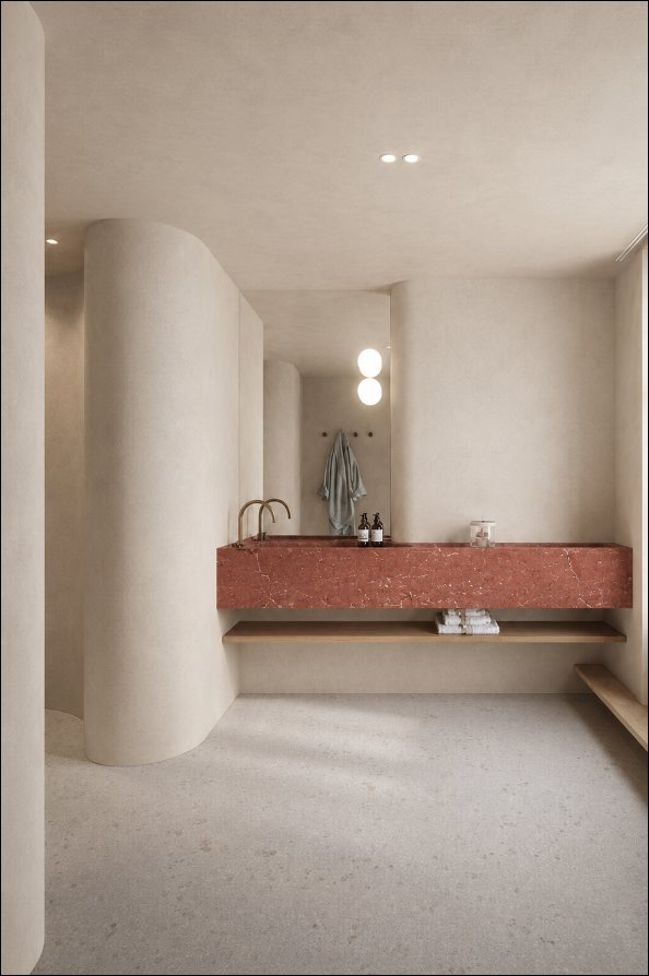 Floating rosso stone basin set against curved plaster walls