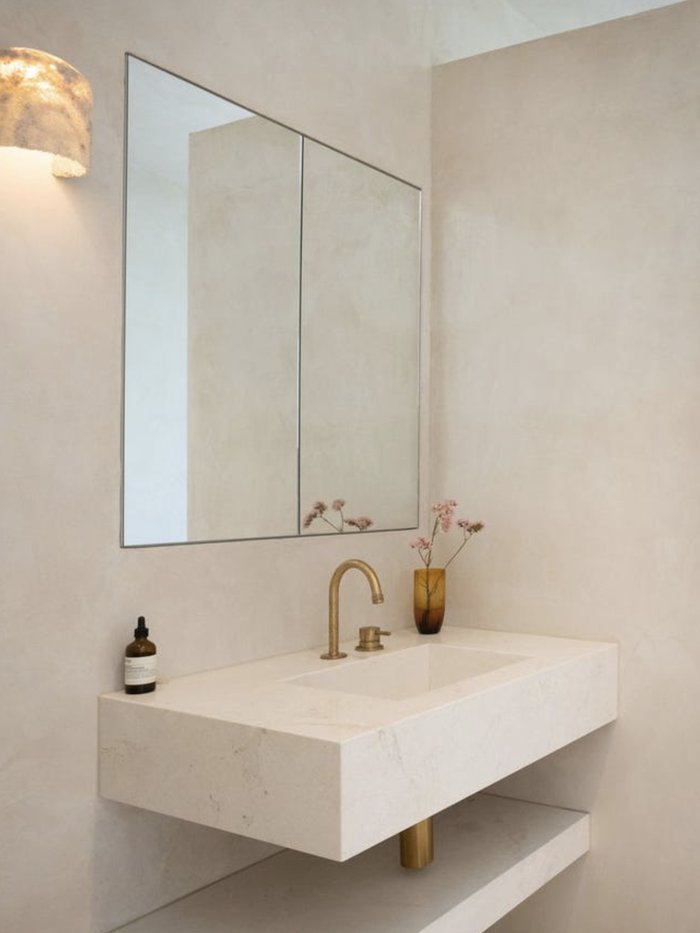 Floating stone vanity beneath a skylight, with a window onto the forest beyond, Komorebi Home