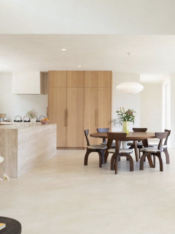 Round timber dining table with oak joinery beyond, Komorebi Home