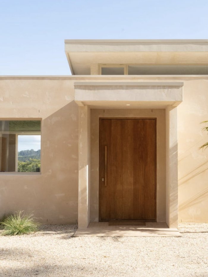Rendered entry facade with a timber front door and palm, Komorebi Home