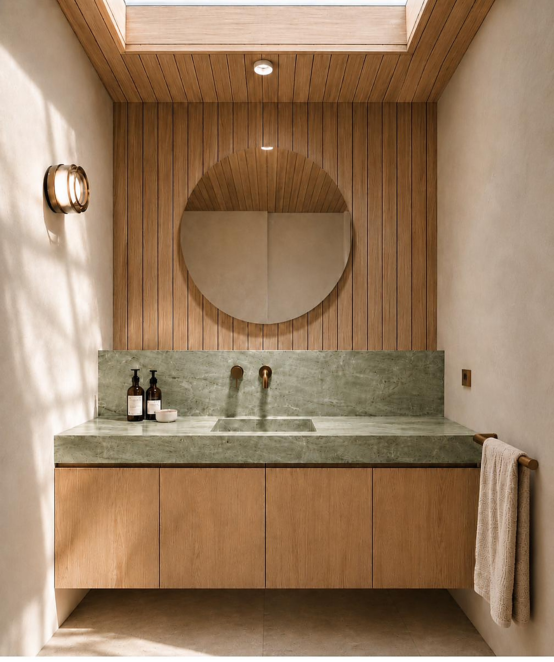 Powder room with skylight, round mirror and green stone vanity, Lennox Head Residence