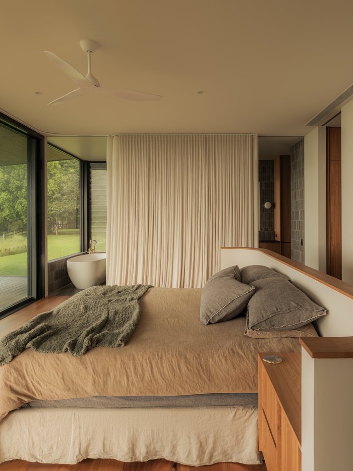 Bedroom with linen bedding and a freestanding bath beyond, Newrybar Residence
