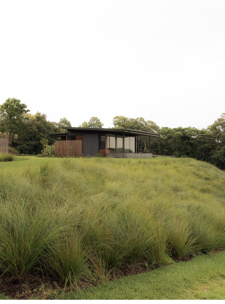 Exterior view across grasses toward the residence, Newrybar Residence
