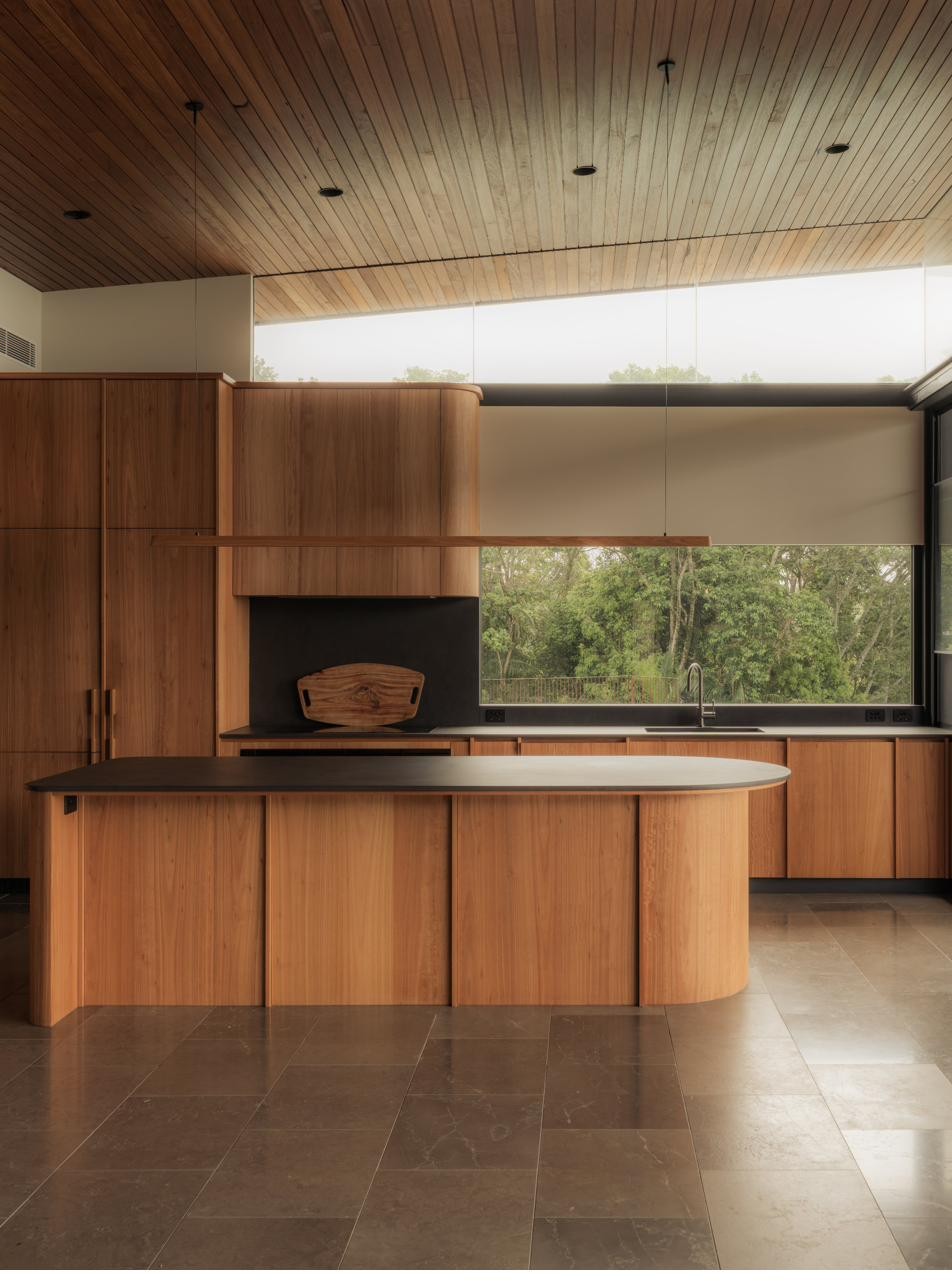 Kitchen island with timber joinery and stone floors, Newrybar Residence