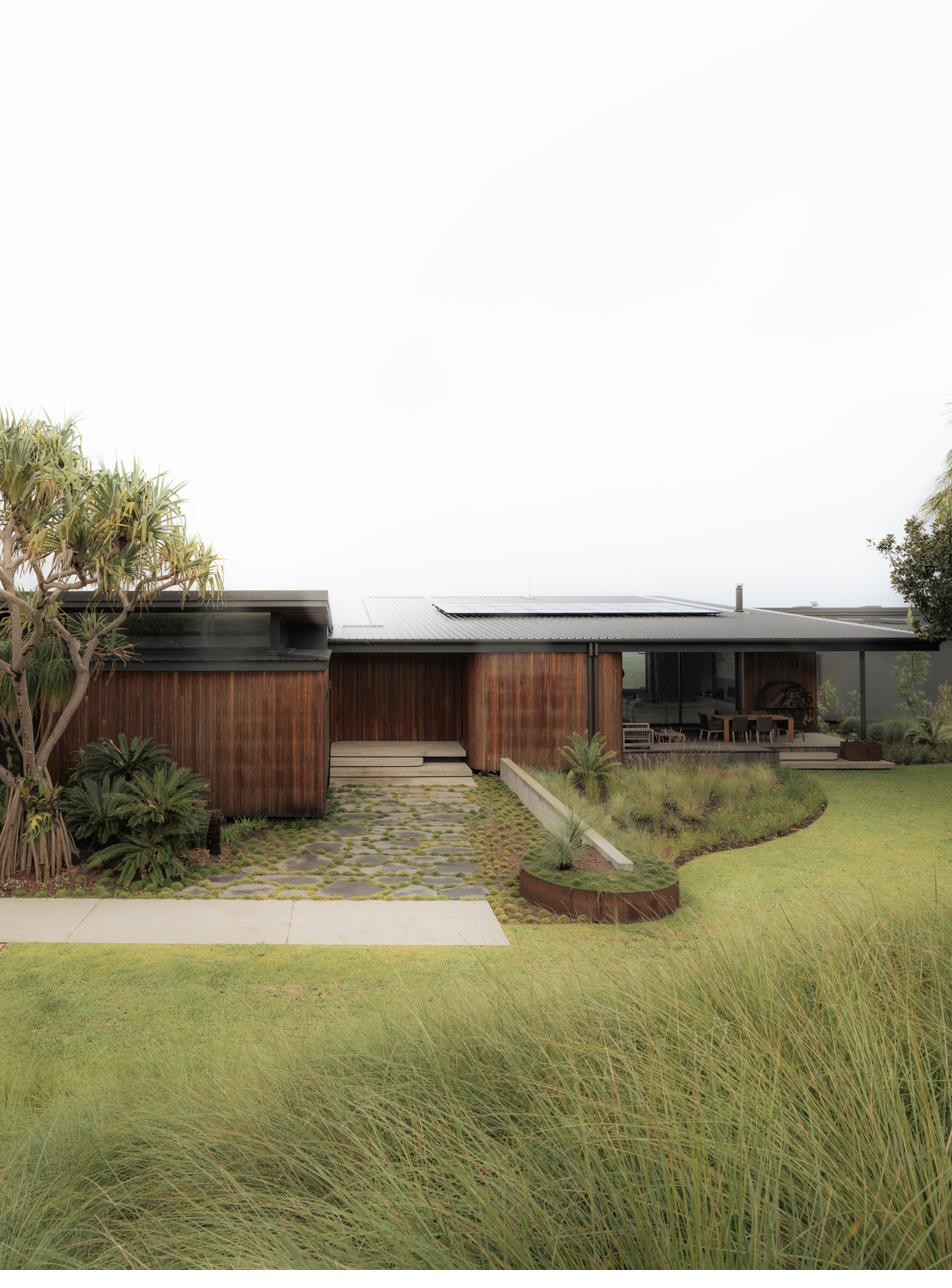 Front entrance with timber cladding and native planting, Newrybar Residence